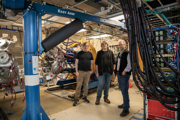Three men surrounded by high-tech science equipment