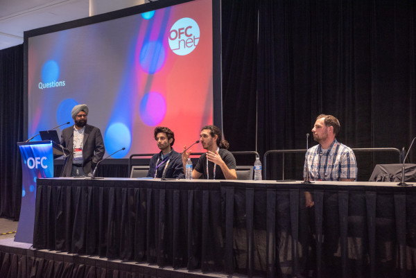 Four men on a panel at a conference