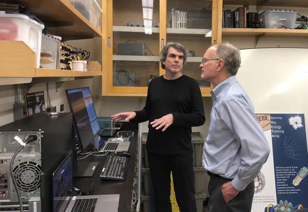 Man showing another man something on a screen