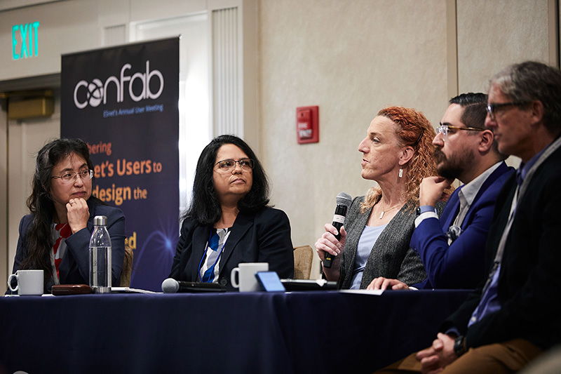 Five people sitting at a table, talking