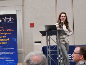 Woman leaning on podium, smiling