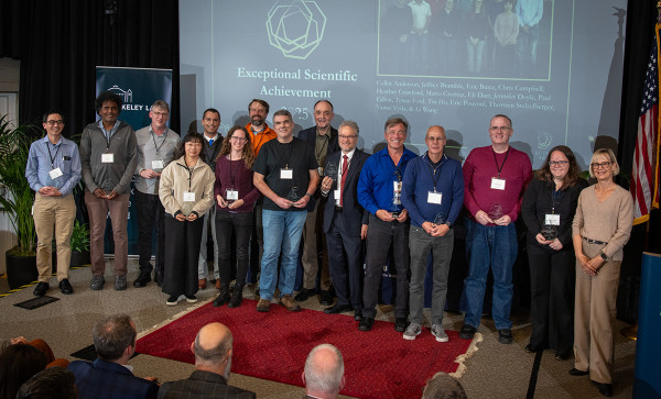 A large group of people on stage holding awards