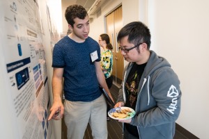 Photograph of two students looking at a poster.