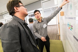 Photograph of two students looking at a poster.