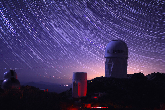 Observatory dome silhouetted against starry sky. 